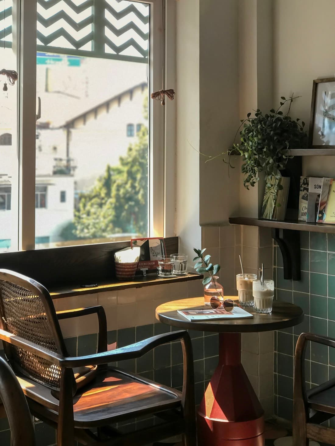 Coin chaleureux d'Hiraya Café : carrelage vert, plantes et lumière douce.